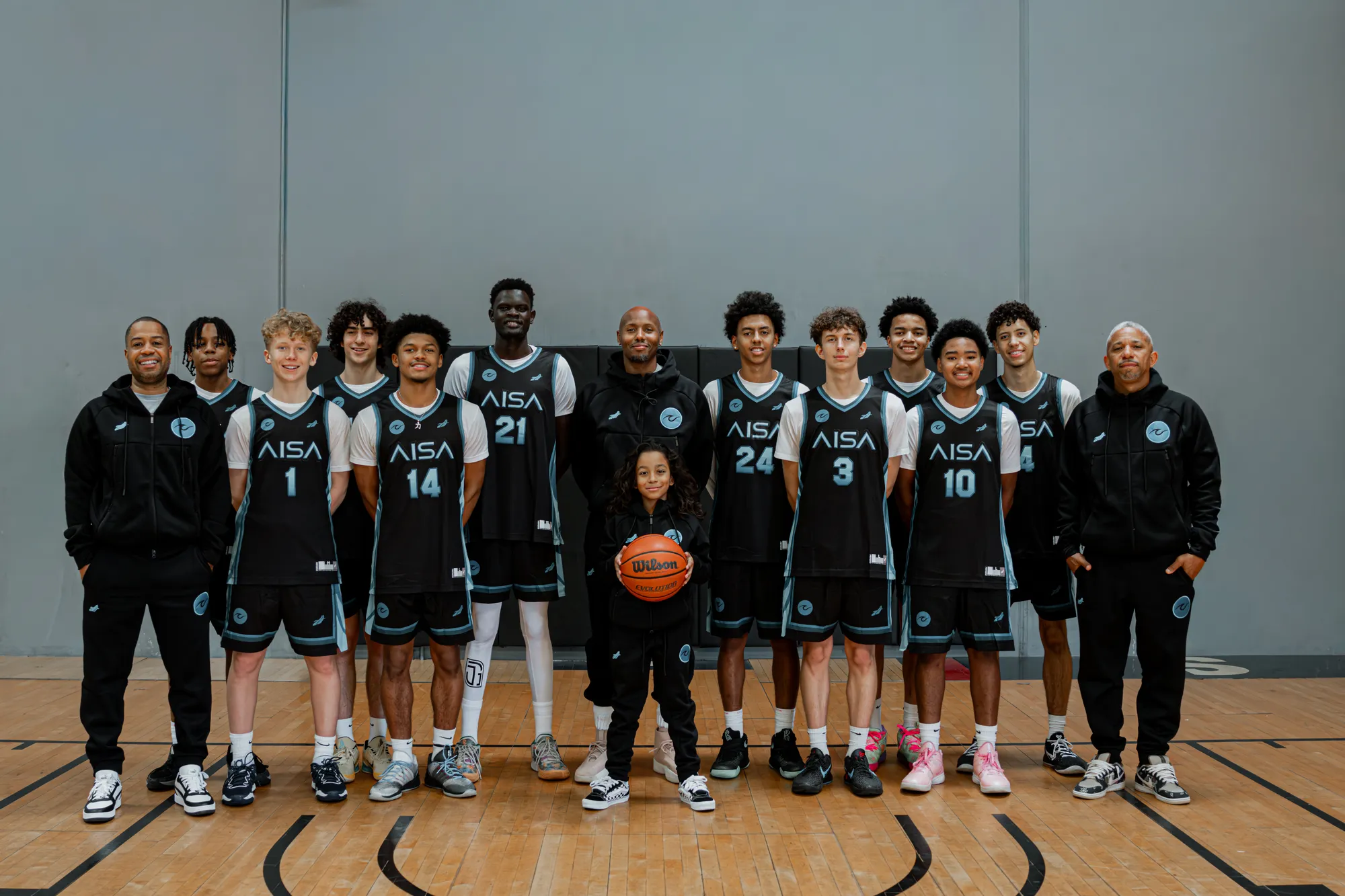 Apex student-athletes and their coach together in the gym