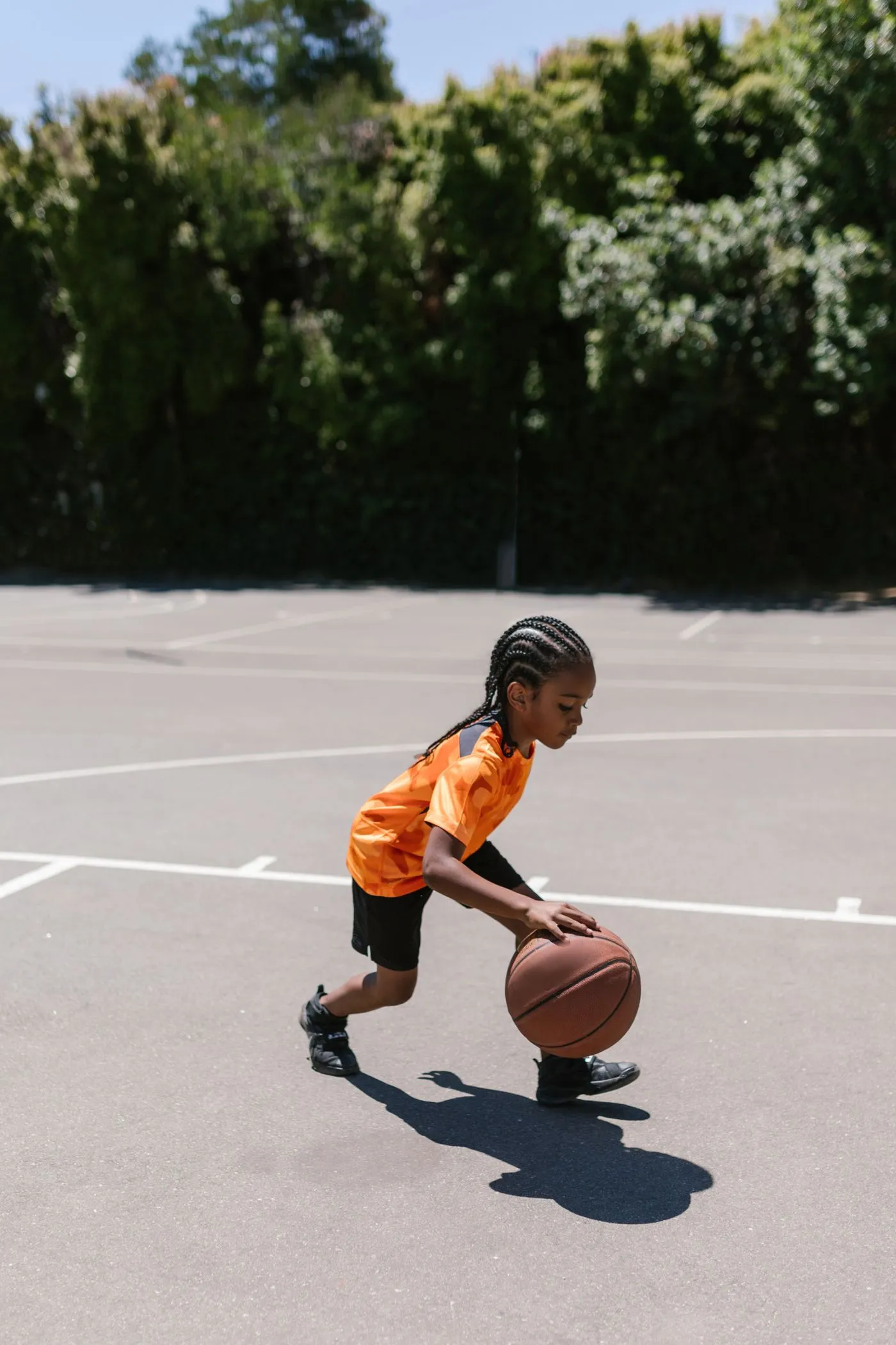A young athlete working on ball-handling drills on an outdoor court